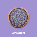 Tørket lavendel i en rund trebol på en lilla bakgrunn, med teksten "AWAKEN" under