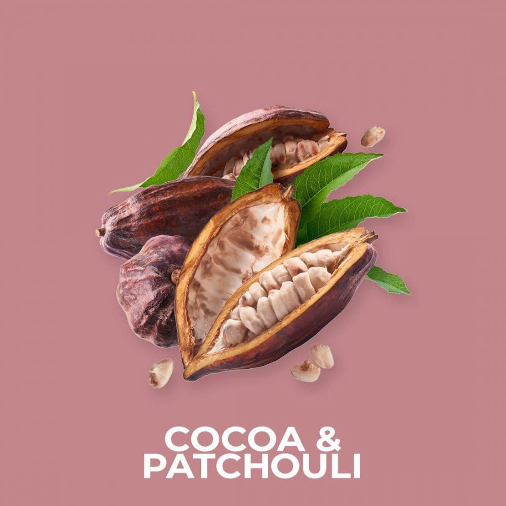 Kakao- og patchouli-duftolje med åpne og hele kakaobønner og grønne blader på rosa bakgrunn
