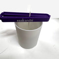 Eazi wick clip holder veken midt i et hvitt lysglass