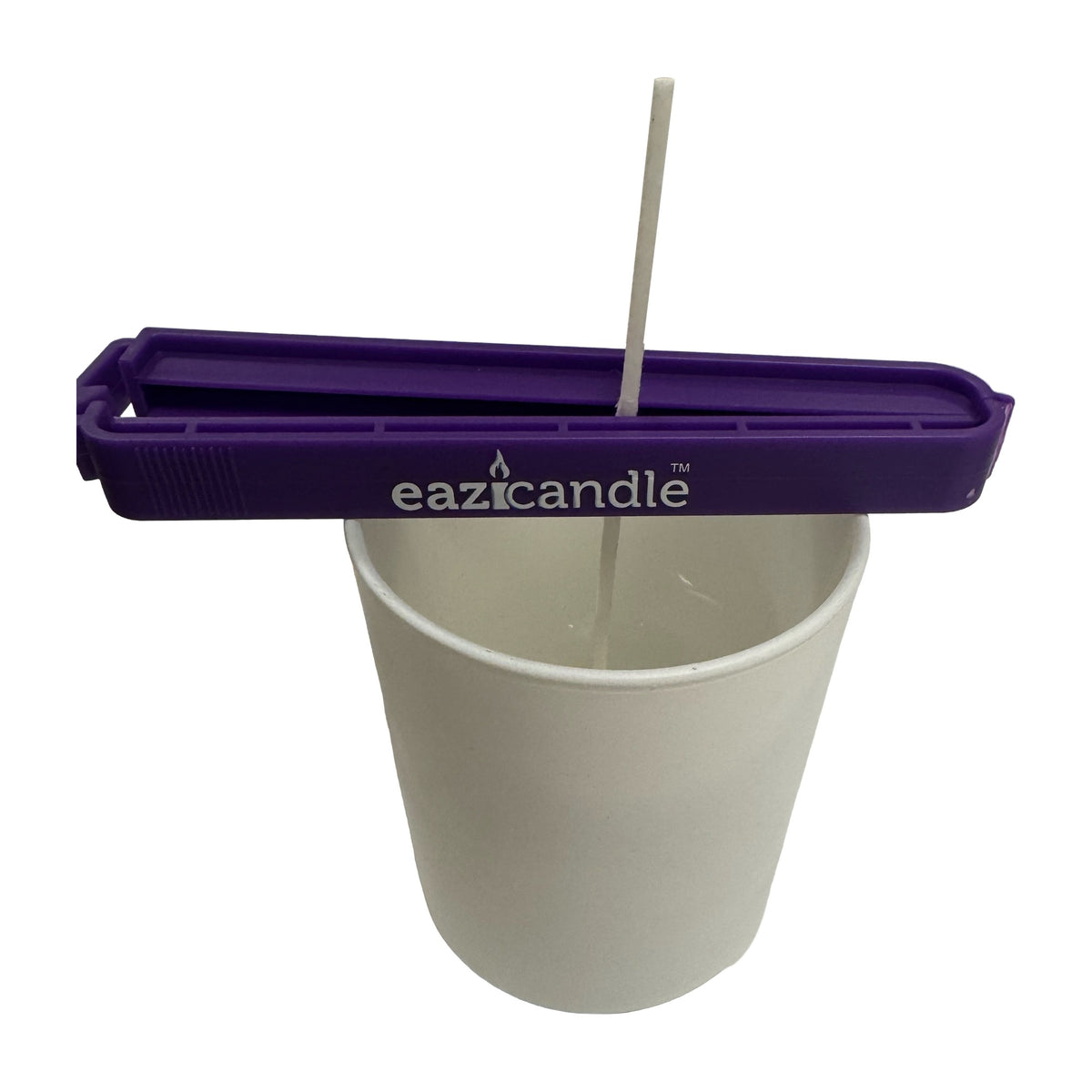 Eazi wick clip holder veken midt i et hvitt lysglass